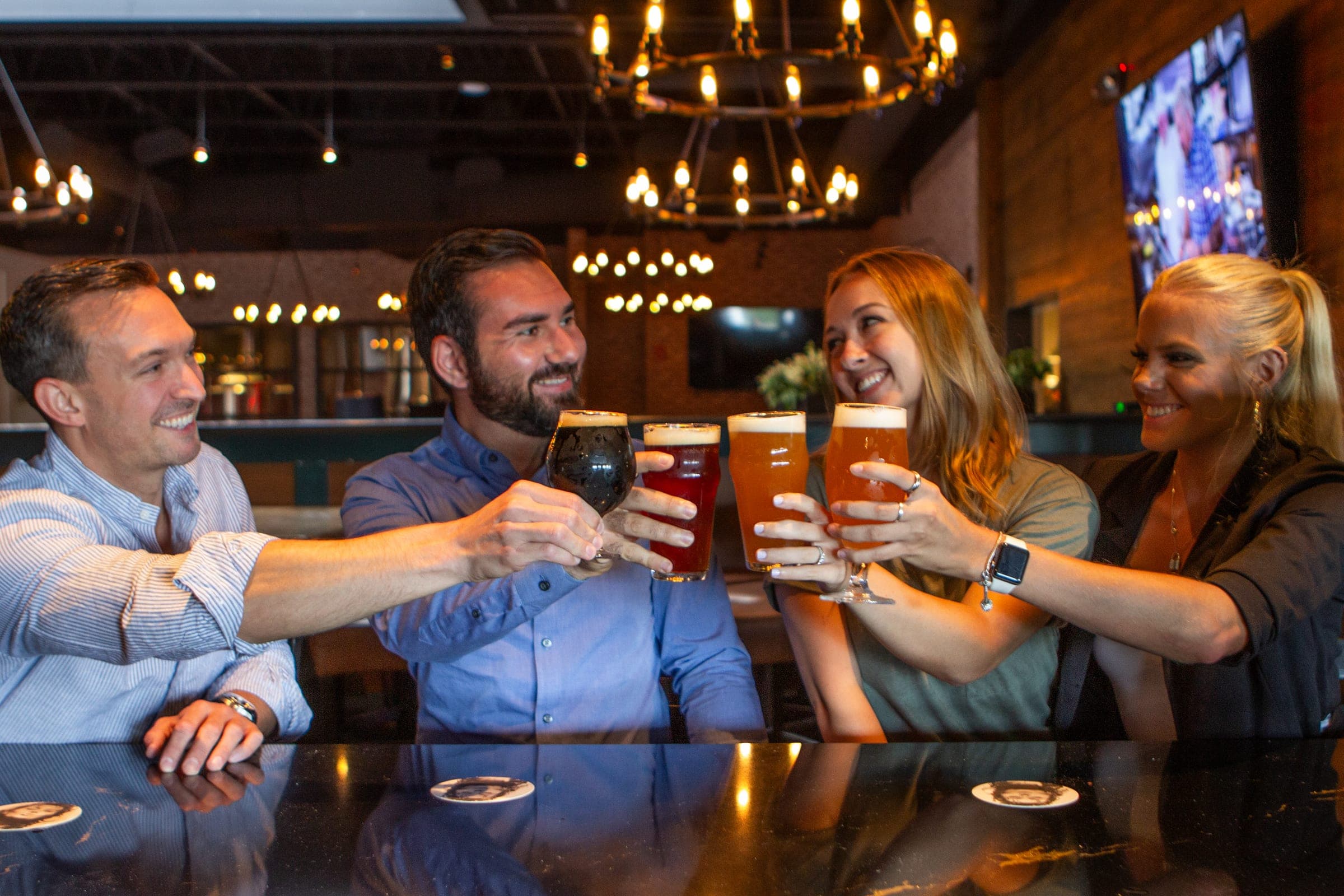 Friends raising a toast with house-brewed craft beers during happy hour in Berwyn PA